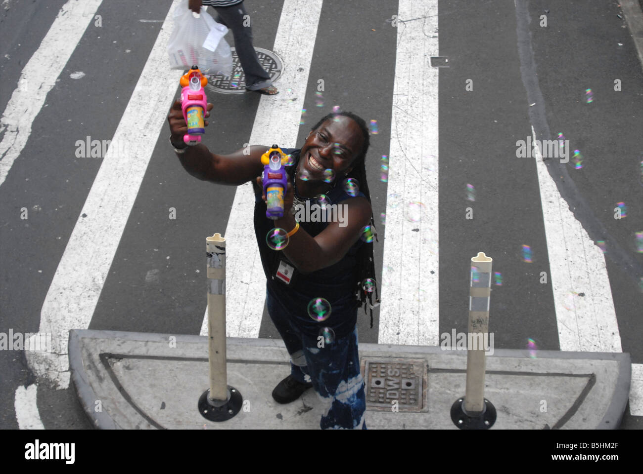 A happy bubble machine ventor on the street in New York, selling to people on busses. Stock Photo
