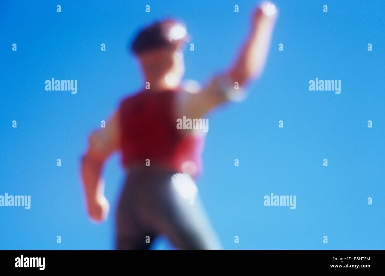 Impressionistic close up of model of farmworker or manual labourer shaking his fist and shouting angrily with blue sky Stock Photo