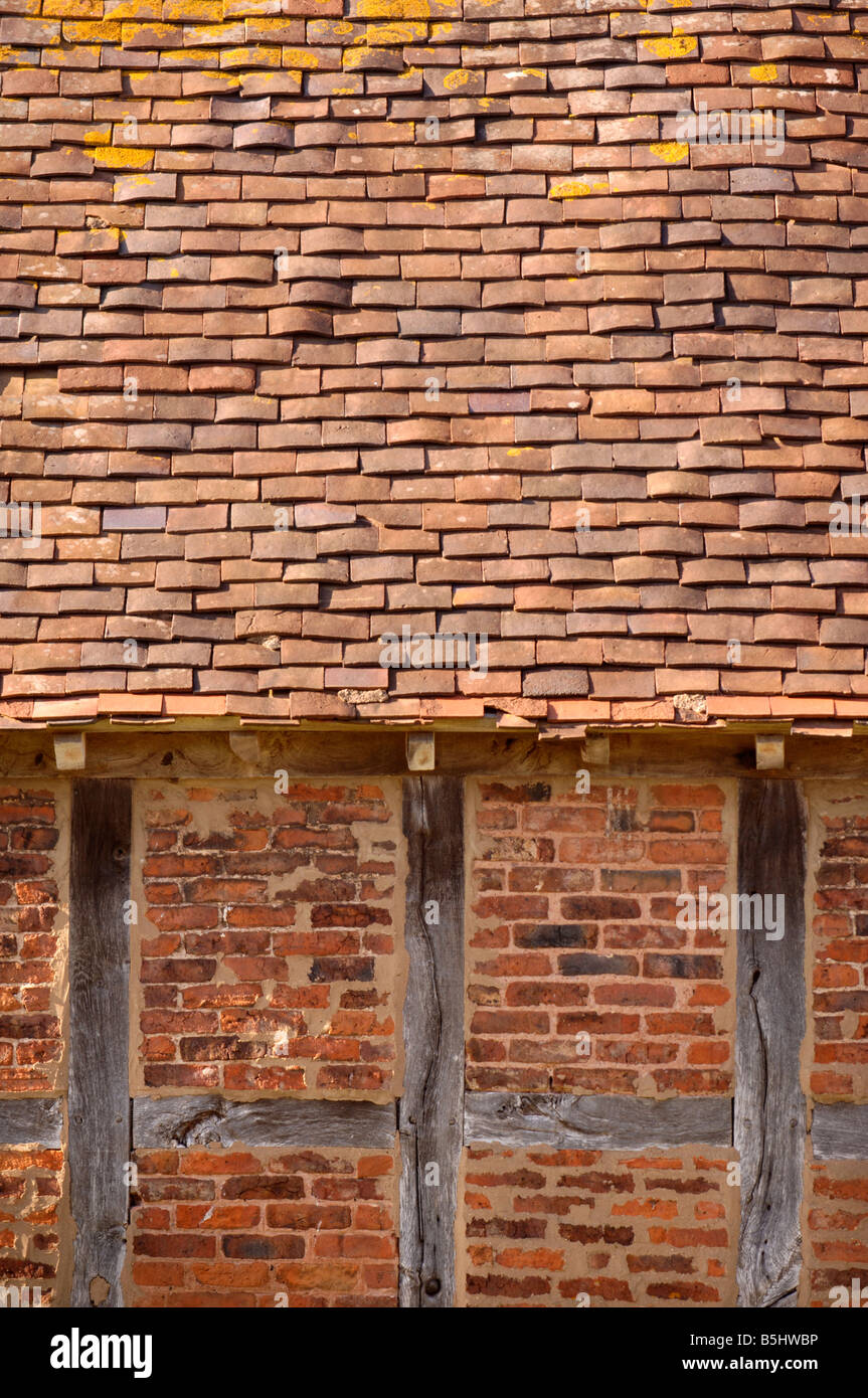 DETAIL OF A RED BRICK AND TIMBER FRAMED BARN WITH CLAY TILED ROOF IN