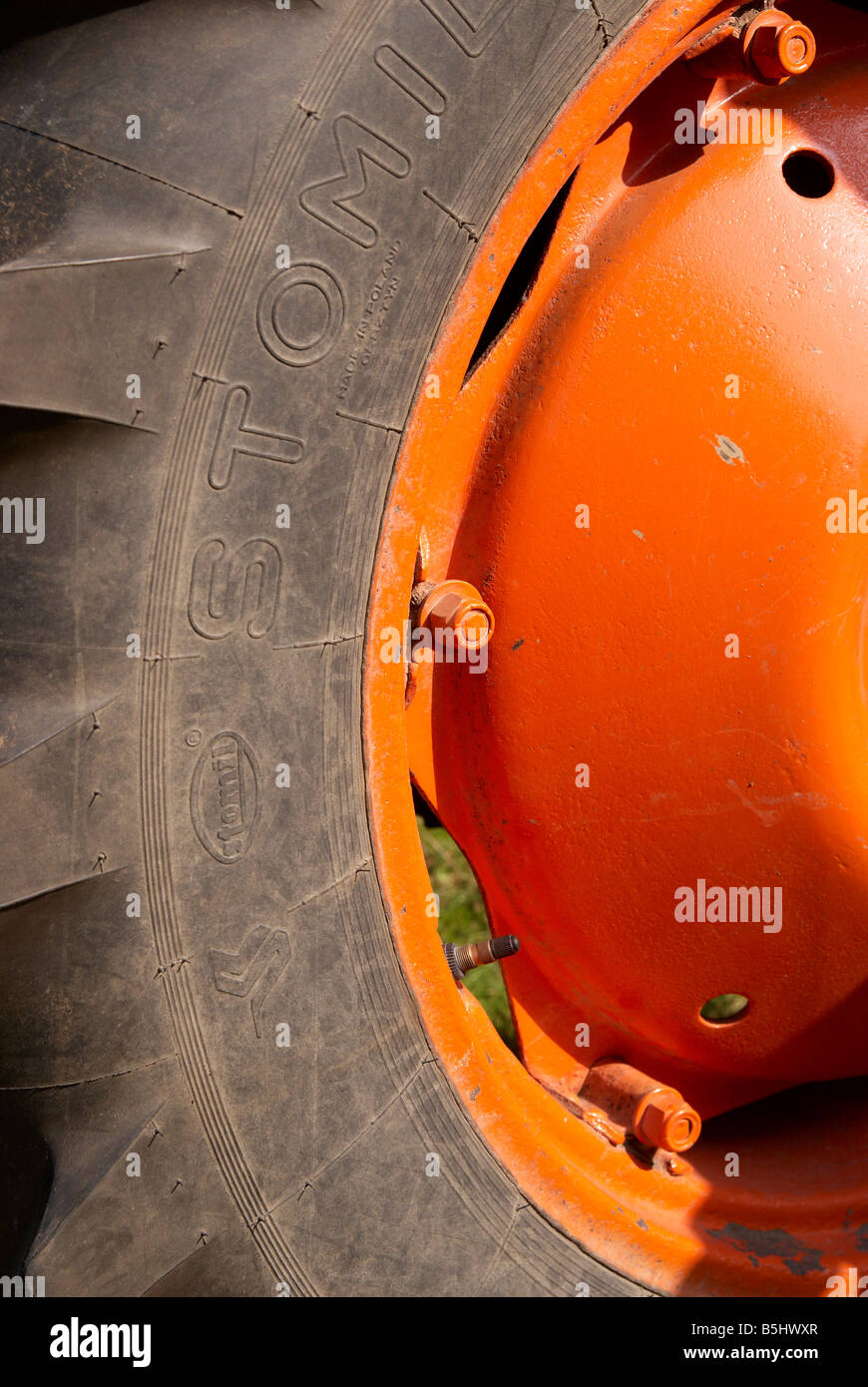 Orange tractor wheel and black tyre on a restored Fordson Major vintage ...