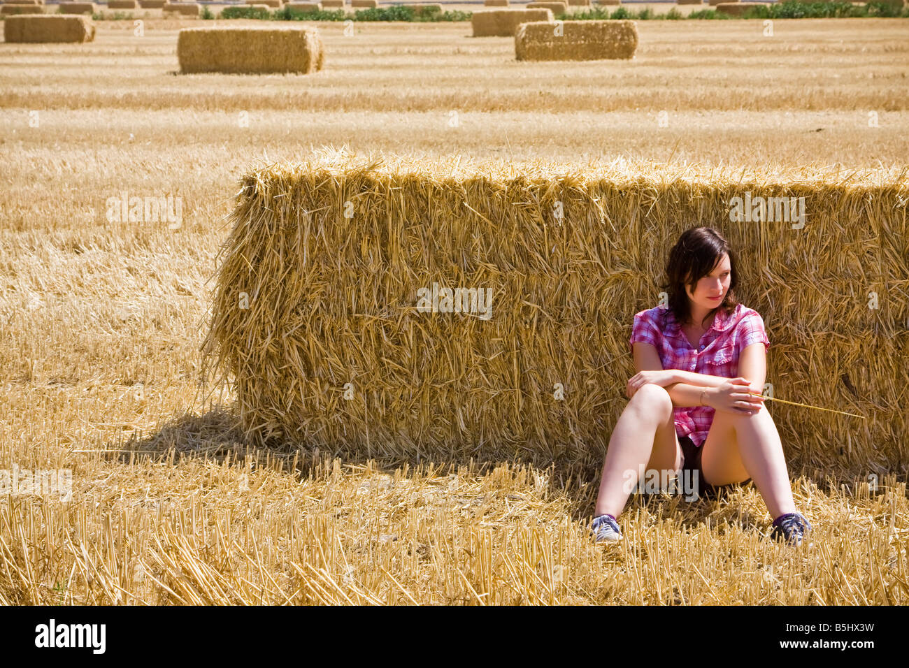 Young farmer resting on the haystack Stock Photo - Alamy