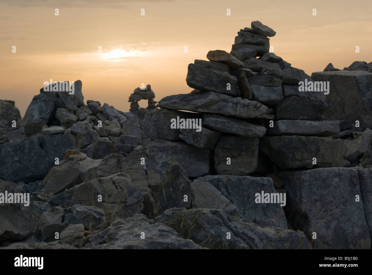 piles of stones rocks put together by visitors into structures, bridges, sculptures on the Croatian island of Zut near Kornati Stock Photo