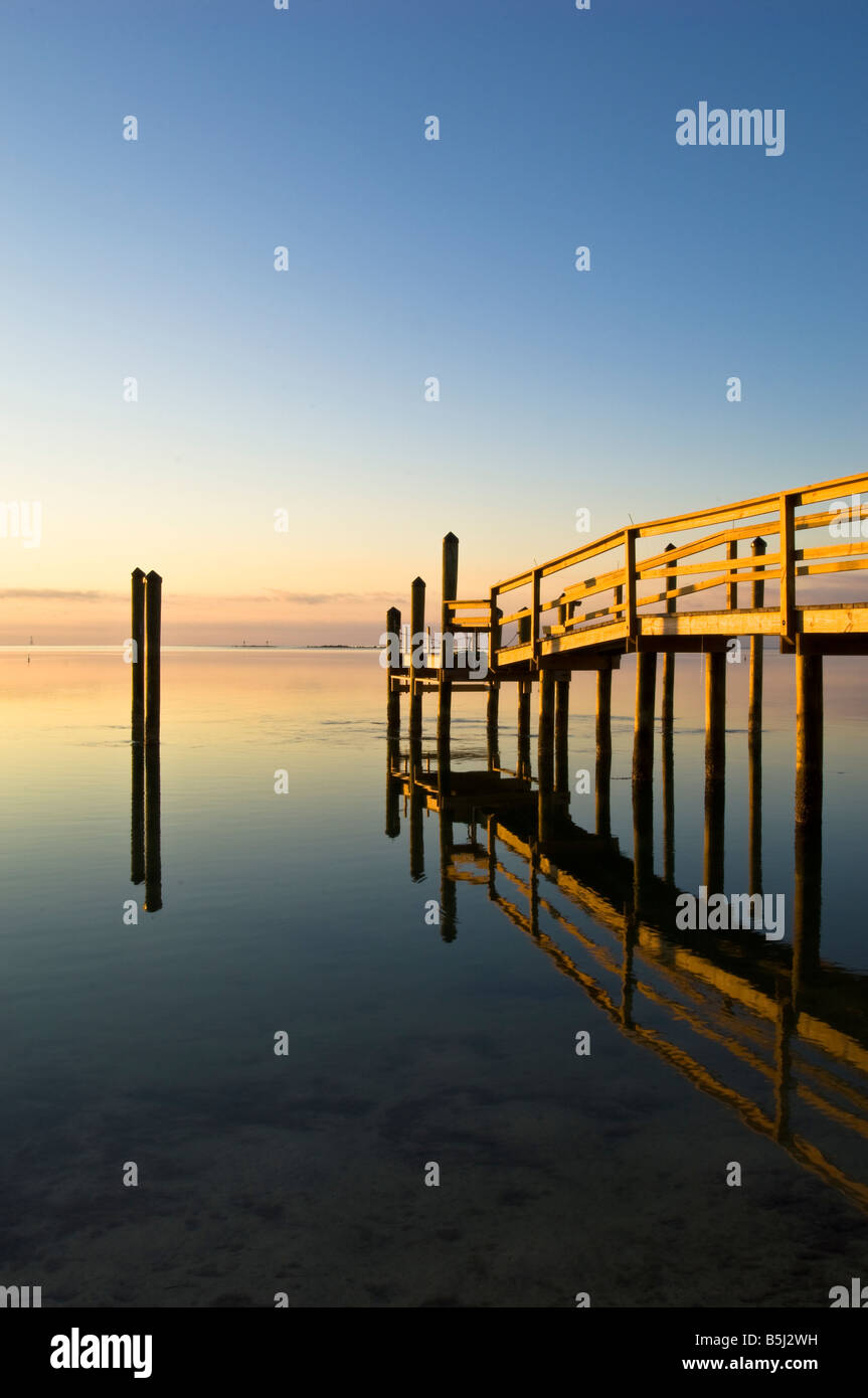 Wooden jetty overlooking ocean at sunrise, Islamorada, Florida Keys, Florida, United States of America Stock Photo
