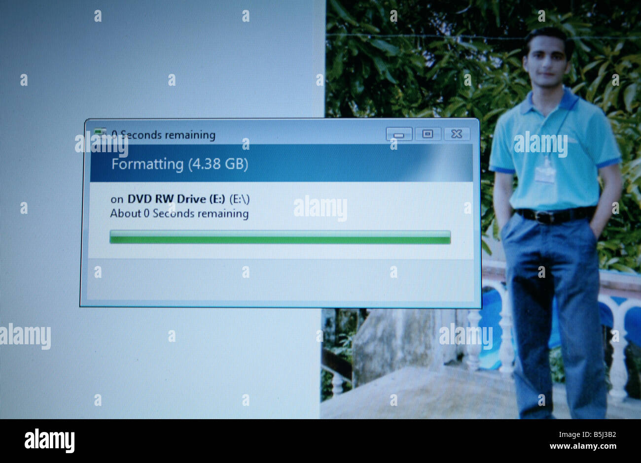 CD DVD formatting on computer of young Indian software professional wearing uniform also used as his screen saver Stock Photo