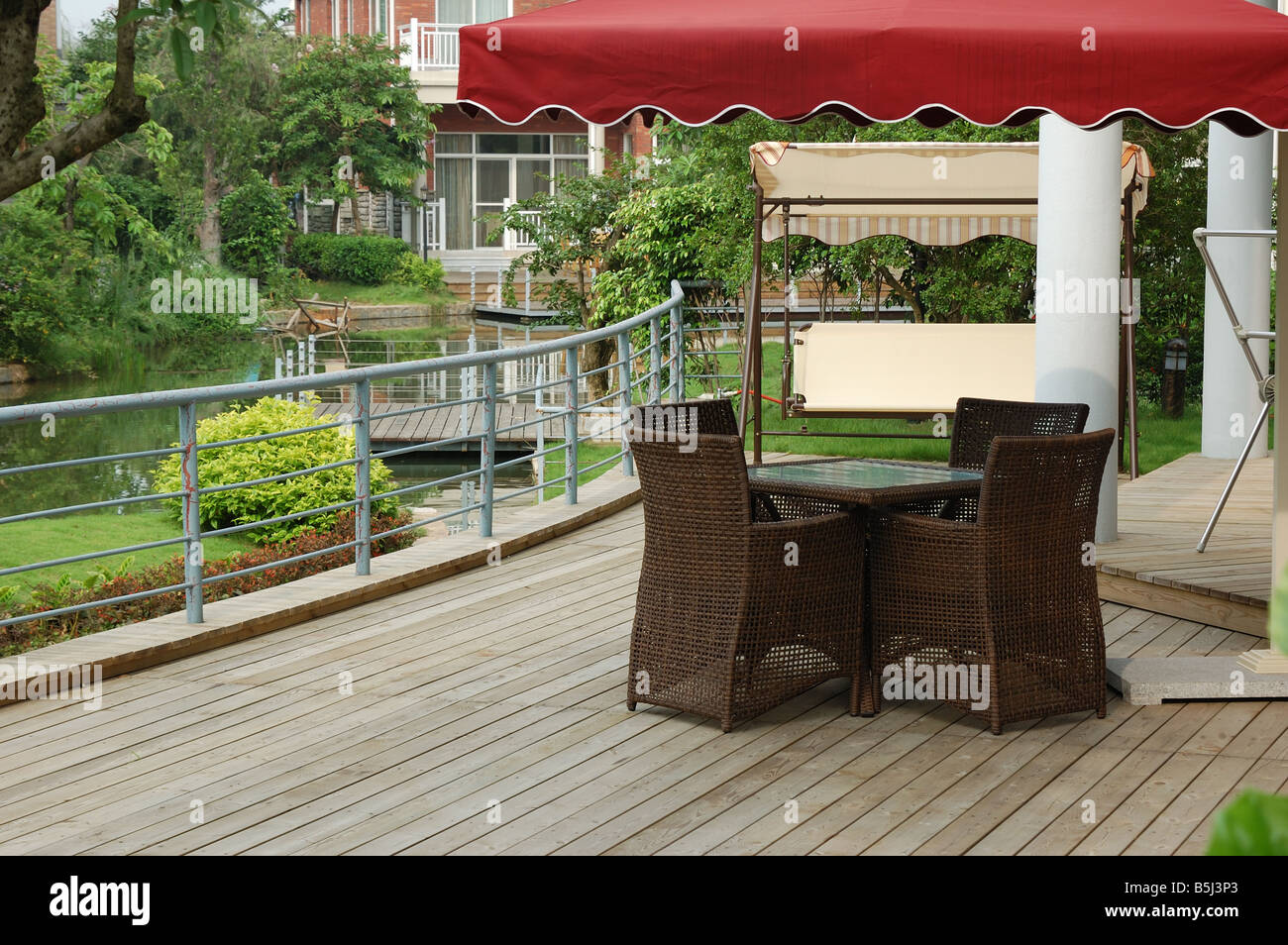 House backyard with table and chairs by a small river Stock Photo
