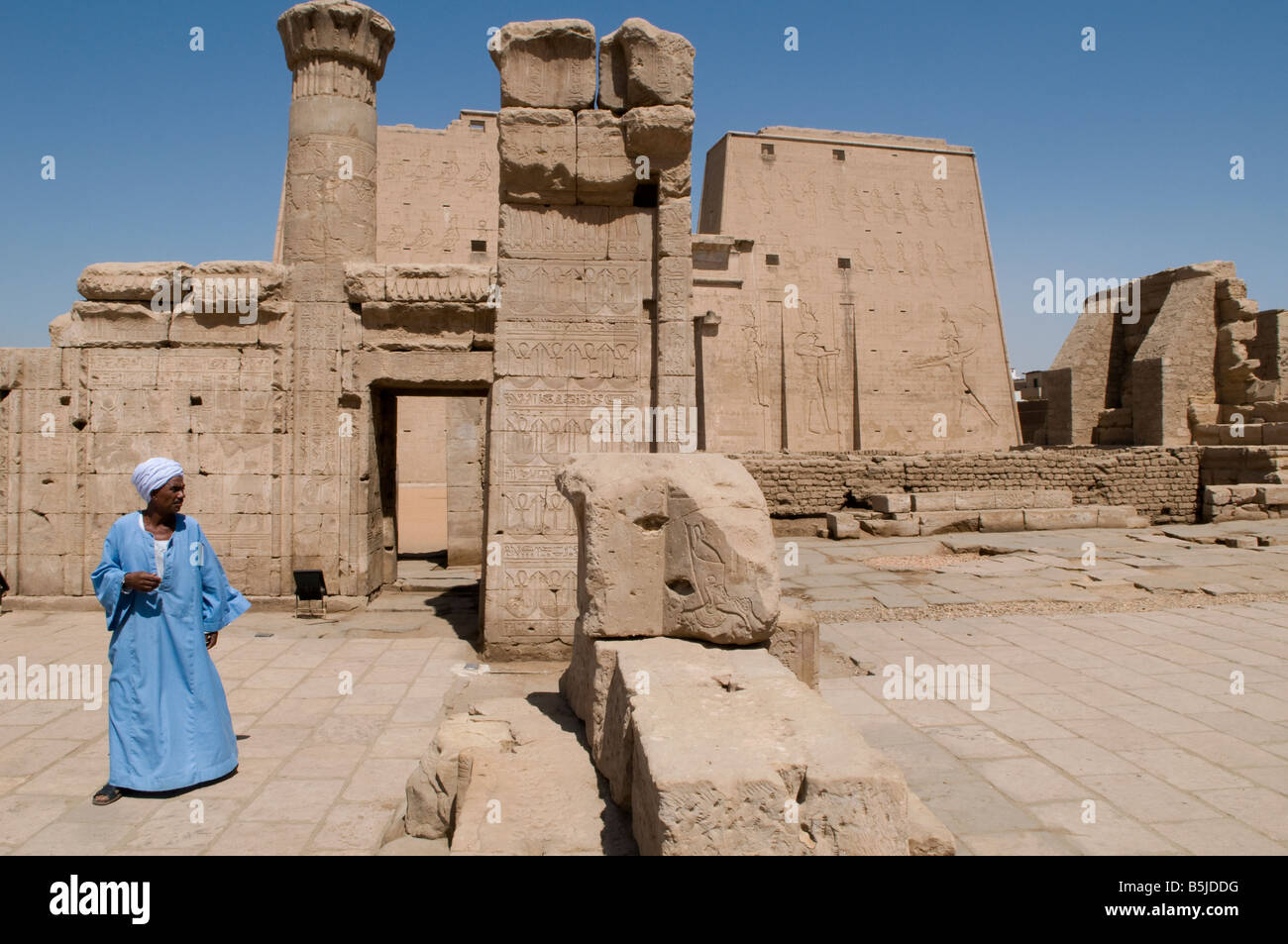 A native guardian wearing the traditional Egyptian garment Galabya at the Edfu Ptolemaic Horus Temple complex in Egypt Stock Photo