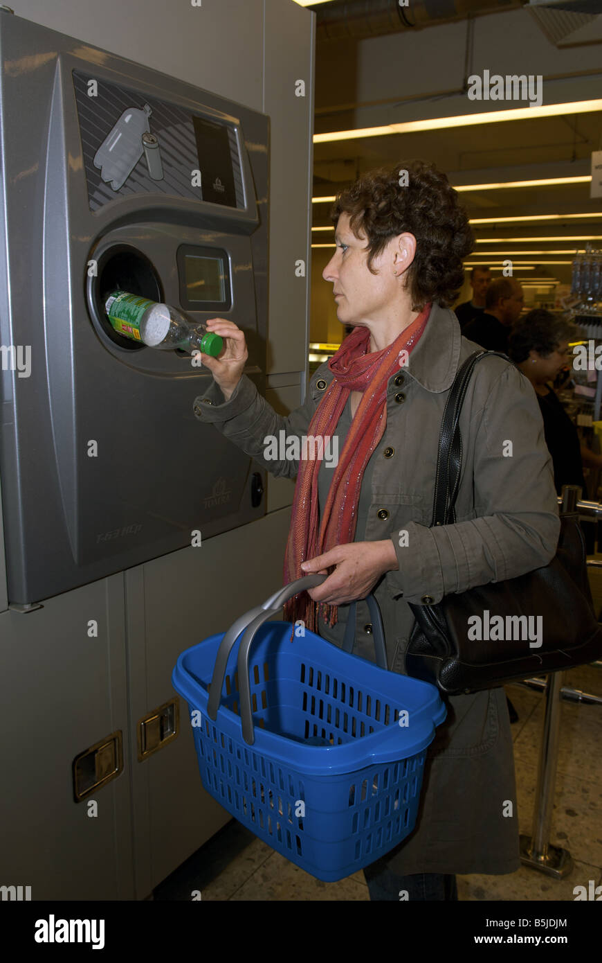 Woman recycling plastic bottles for cash at a German supermarket, Leichlingen, North Rhine