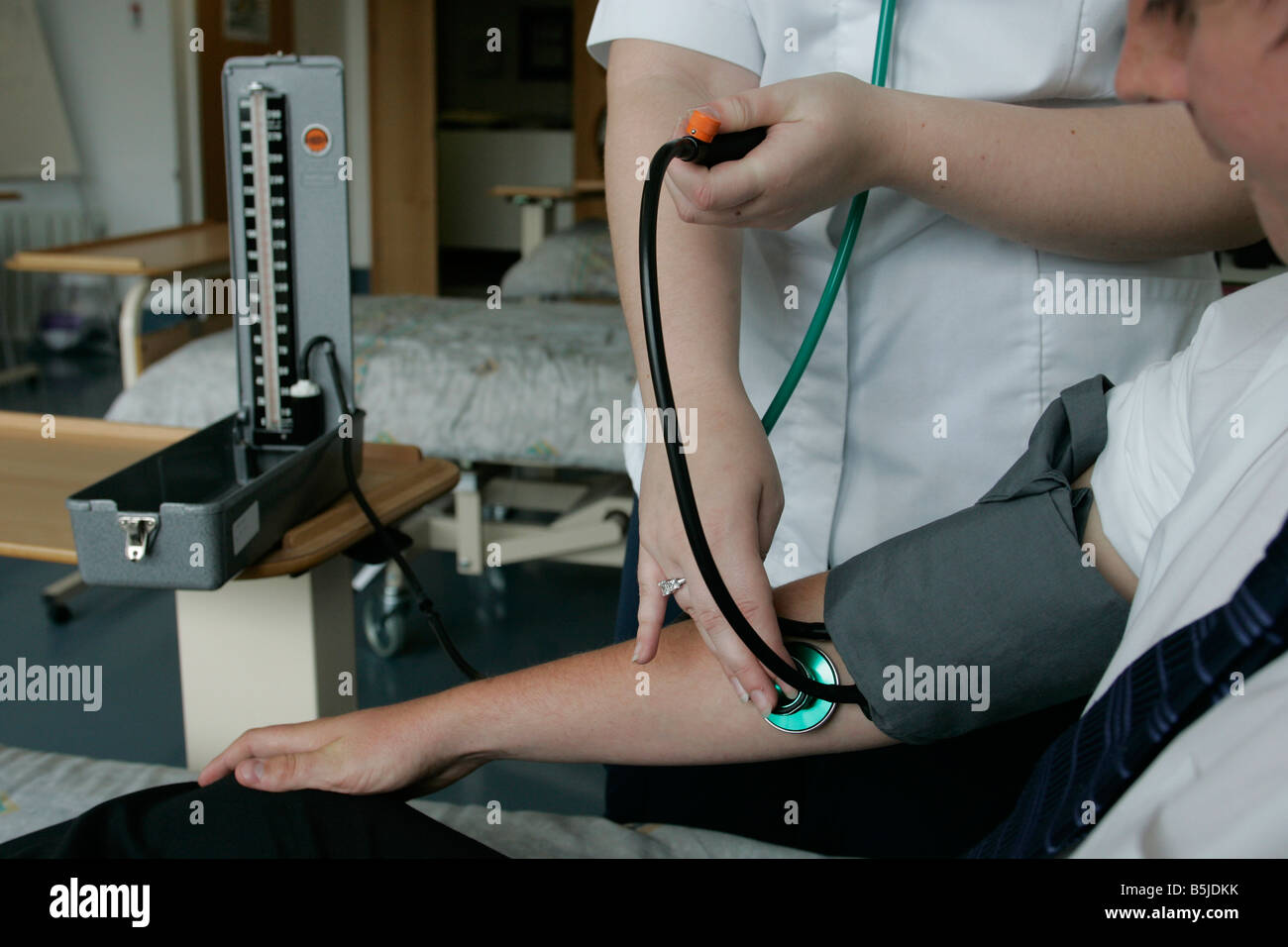 A student nurse taking someones blood pressure on the practice ward at Caledonian University were she is currently studying in Stock Photo