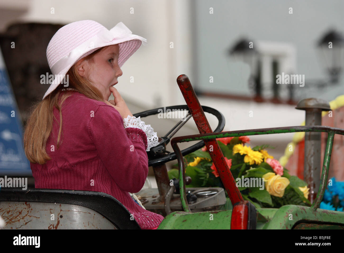 beautiful young girl and flowers on a tractor Stock Photo