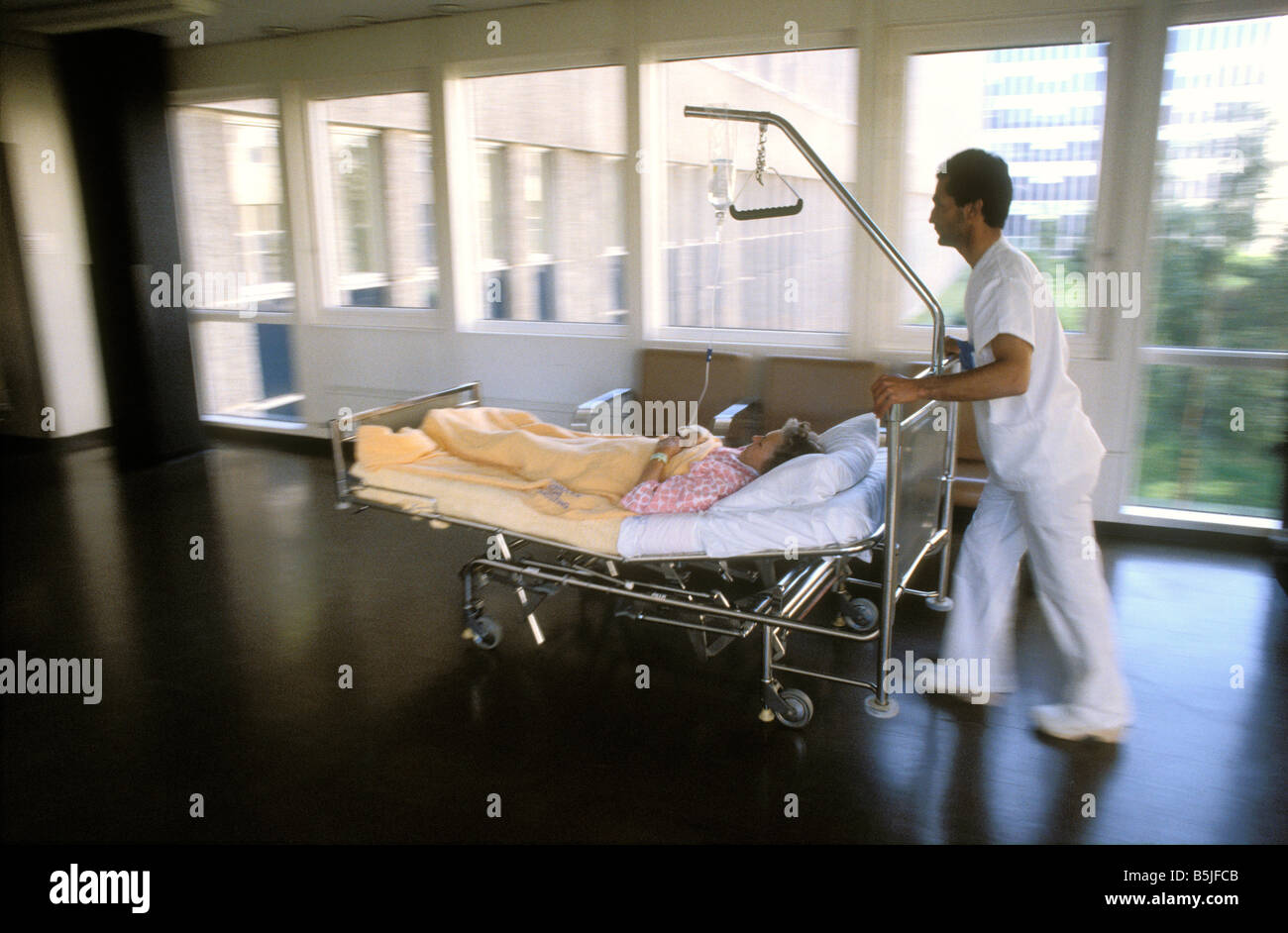 orderly in a hospital transports a bed with patient Stock Photo Alamy