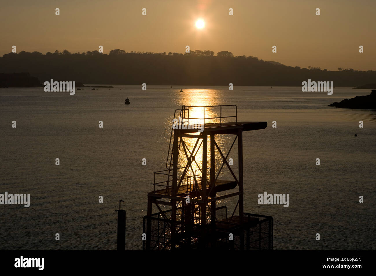 diving board on Plymouth hoe with golden sunset in background with sea