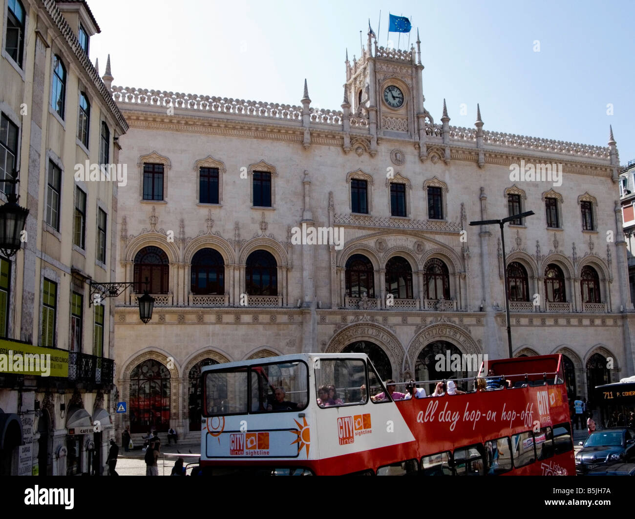 Open top tourist bus outside the Neo-Manueline style railway station at Rossio, Lisbon, Portugal Stock Photo
