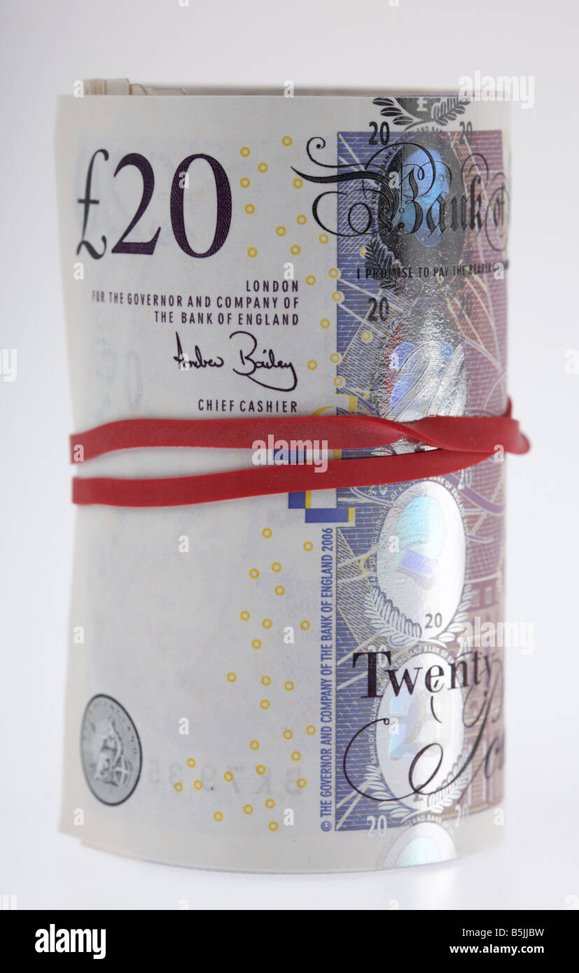 wad of 20 pounds sterling bank notes cash tied up in a roll with elastic band Stock Photo