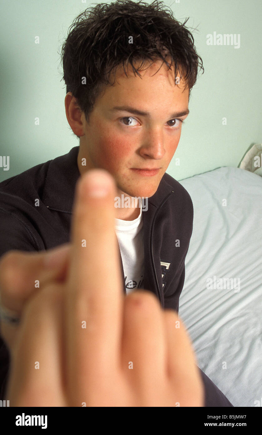 teenage boy sticking middle finger up to camera Stock Photo