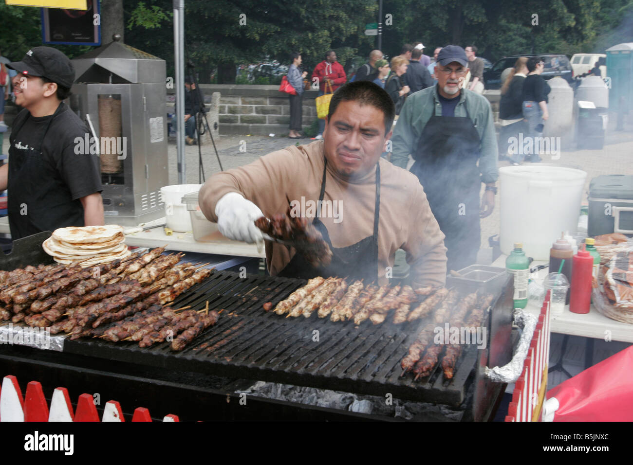 Food vendor grills meat at a street fair in Park Slope Brooklyn New