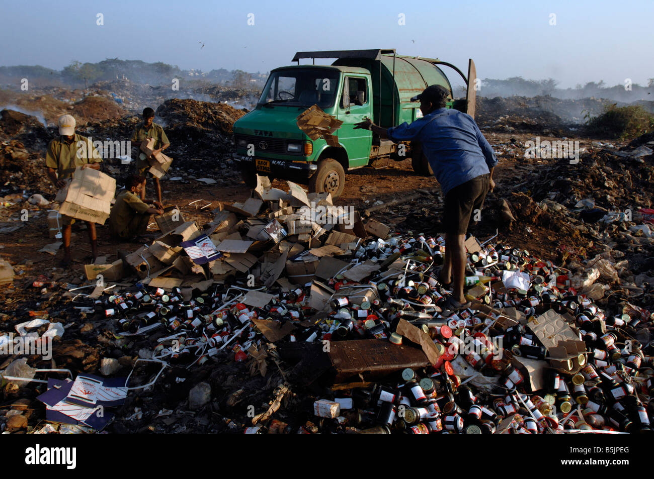 Rubbish dump near the town of Mapusa North Goa India. Local council refuse collectors sort through rubbish for items to sell. Stock Photo