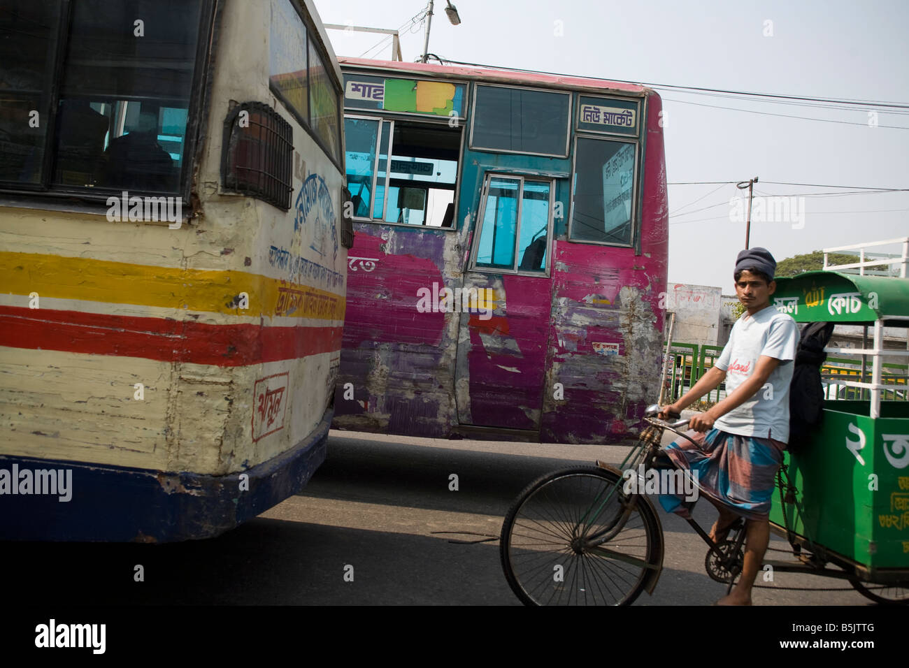 Rickshaw puller in traffic Dhaka Bangladesh Stock Photo