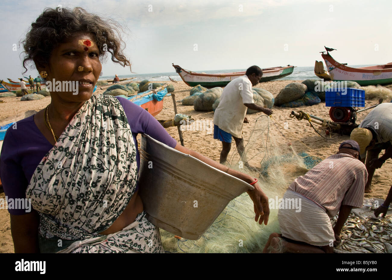 HAI Thalanguda fishermen extract fish from their nets women collect the fish to sell 3 years after fatal tsunami hit them Stock Photo
