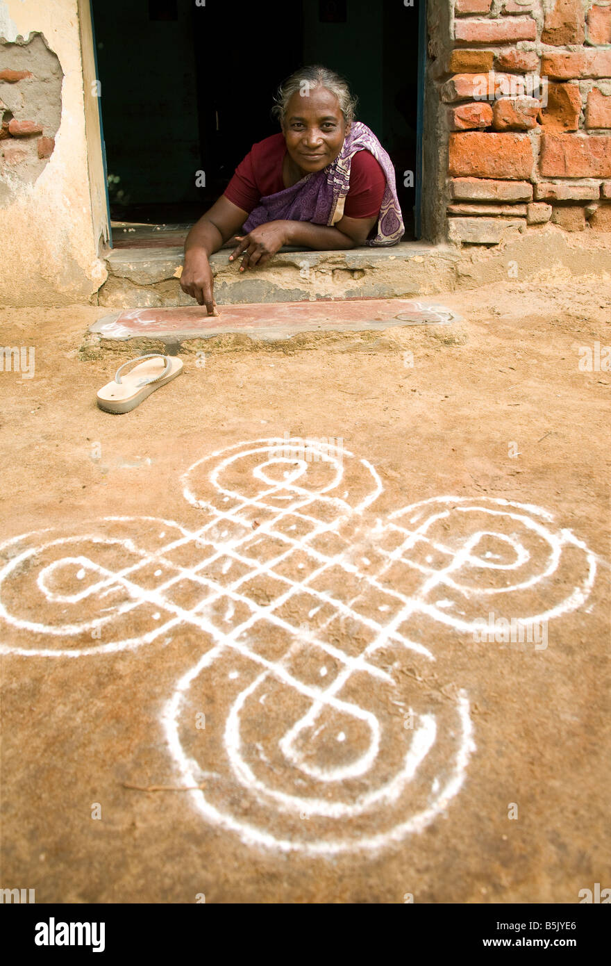 Innovative woman drawing Hindu symbols on the street to earn money in Palpanacherry village India Stock Photo
