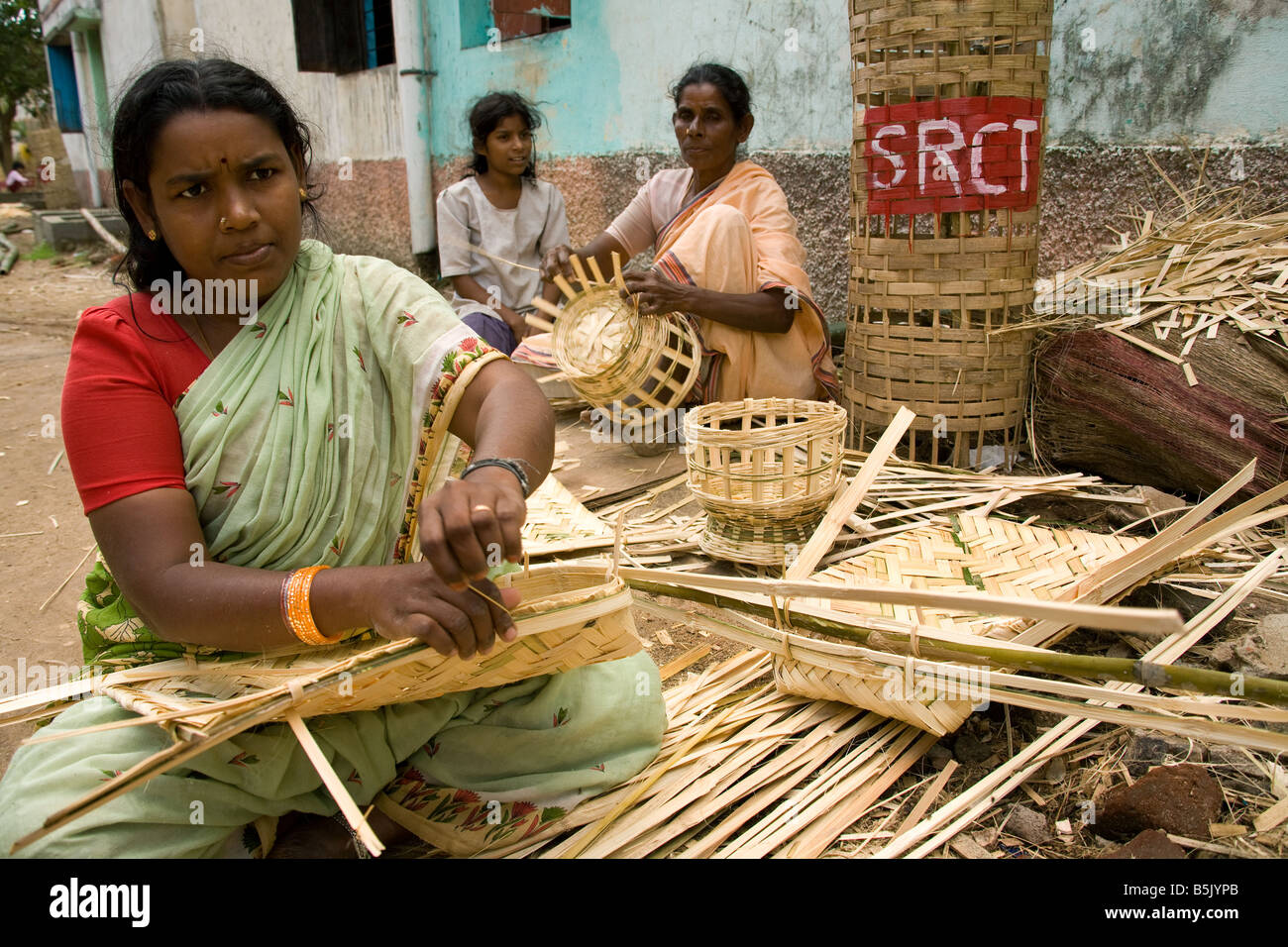 Women of Velipalayam self help group sit in the street weaving mats baskets for income generation after Tsunami Stock Photo
