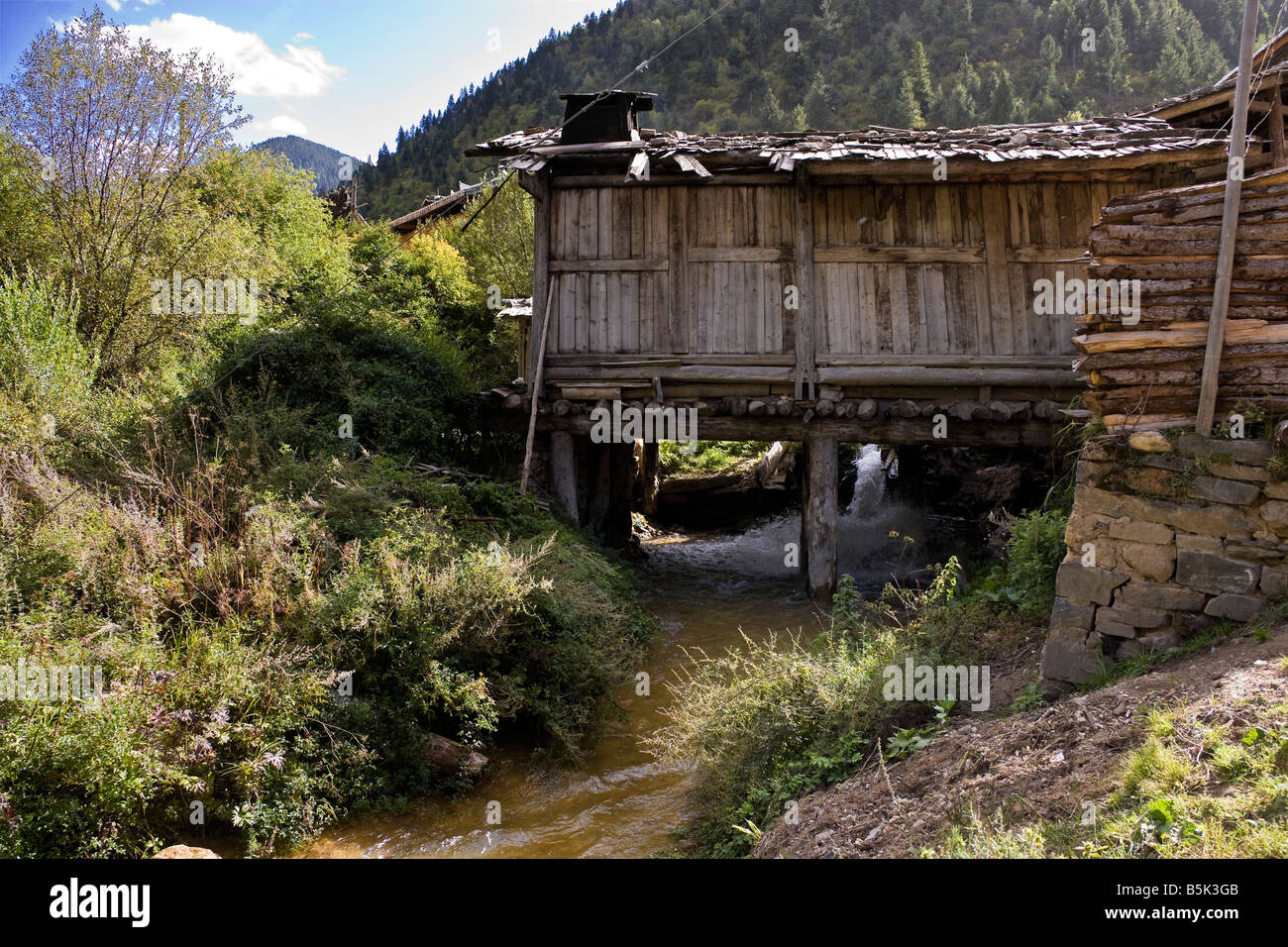 Wooden building built across river in Mounigou valley near Songpan in Sichuan Province China JMH3483 Stock Photo