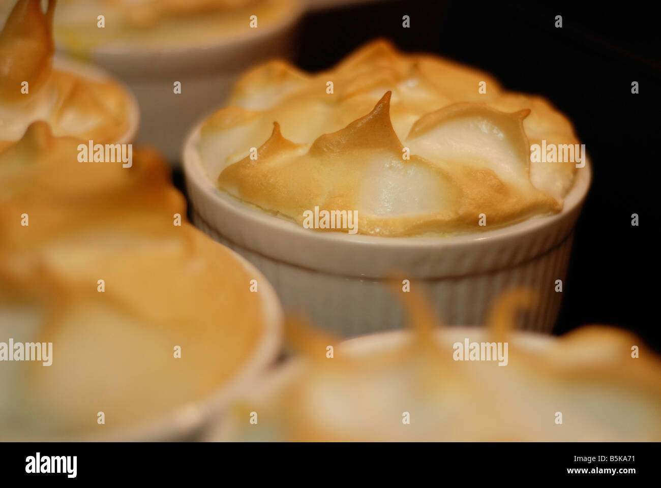 Individual lemon meringue pies baking in the oven Stock Photo