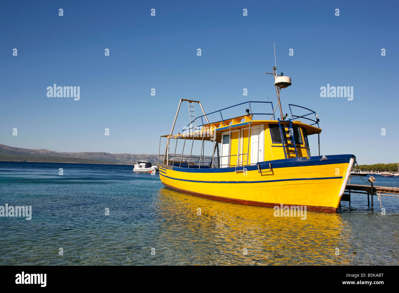 Yellow diving boat in harbour on Brac island in Croatia Stock Photo