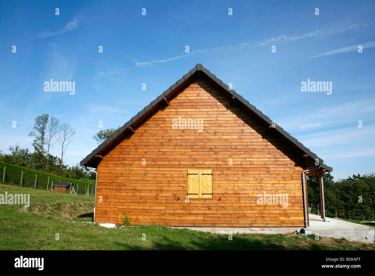 Wooden chalet in green garden and blue sky Correze France Stock Photo