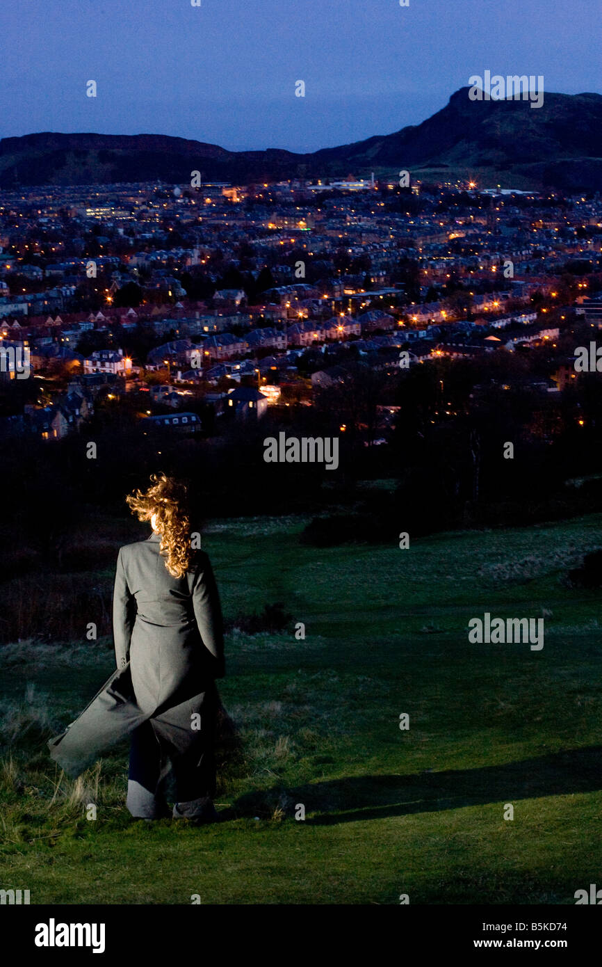 Girl looking over Edinburgh night scape Stock Photo