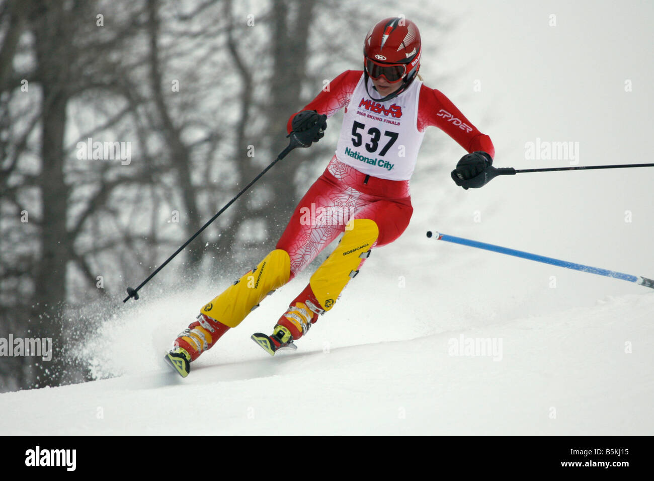 Teenage girl skier at a gate in an alpine slalom race. Stock Photo
