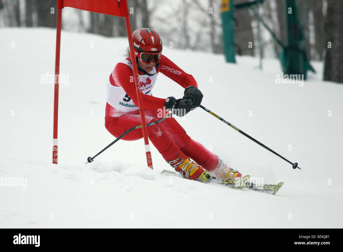 Teenage girl turning at a gate during a downhill giant slalom ski race. Stock Photo