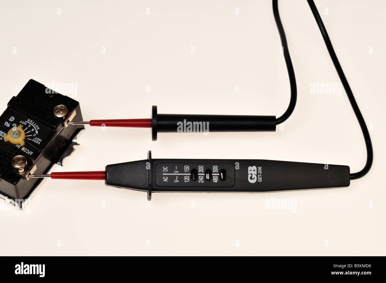 Electric AC power tester with probes on water heater thermostat on white background Stock Photo