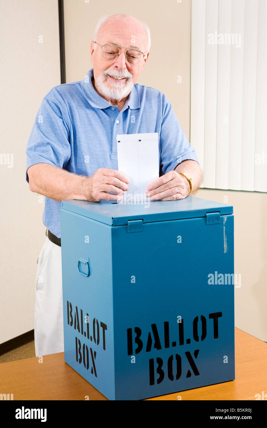 Handsome senior man casting his ballot at the polls Stock Photo