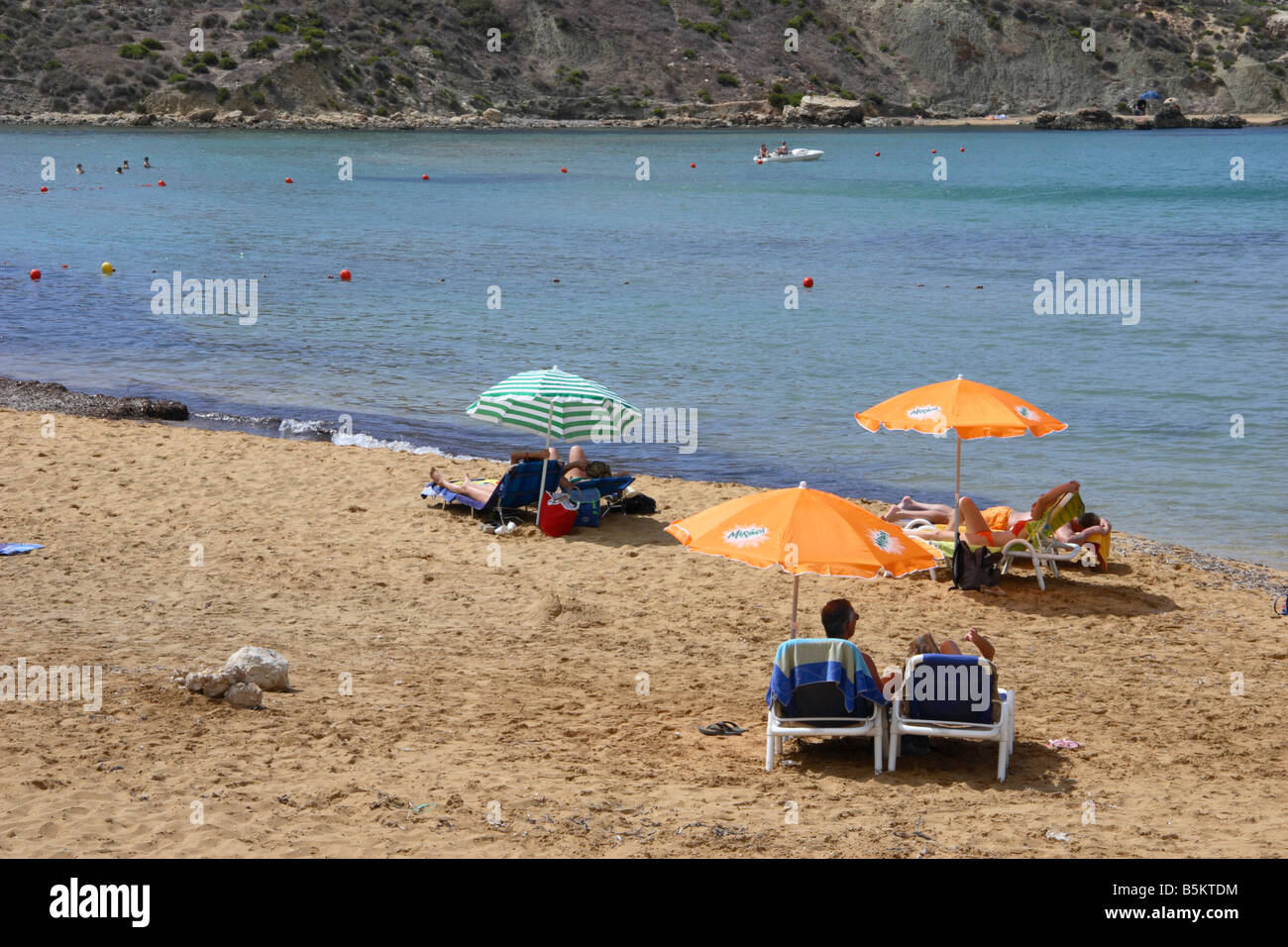 Sunbathing on the 'golden sandy' beach of 'Ghajn Tuffieha Bay', northwest Malta. Stock Photo