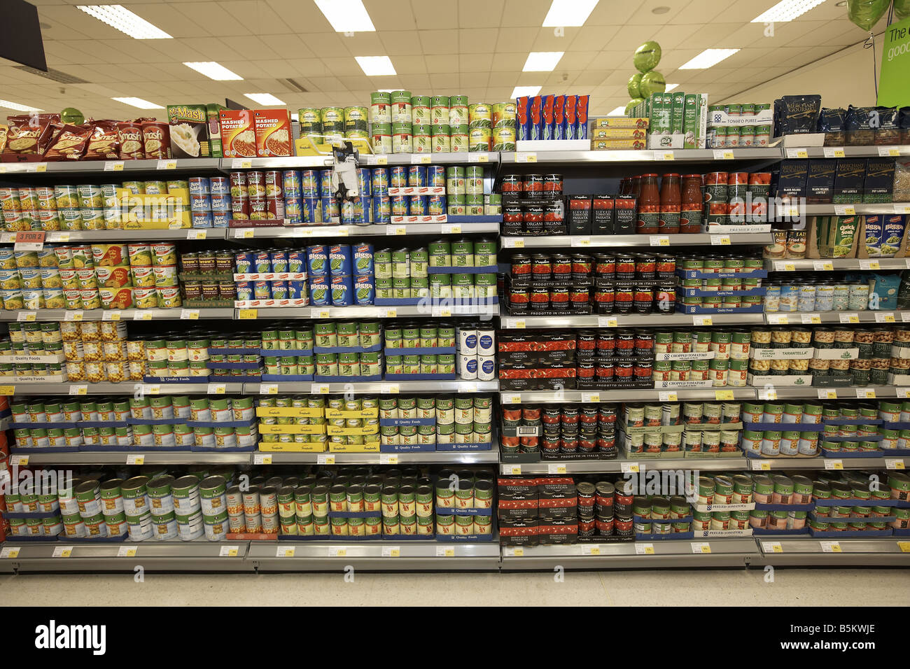 Canned tinned food stacked on supermarket shelves Supermarket interior Stock Photo