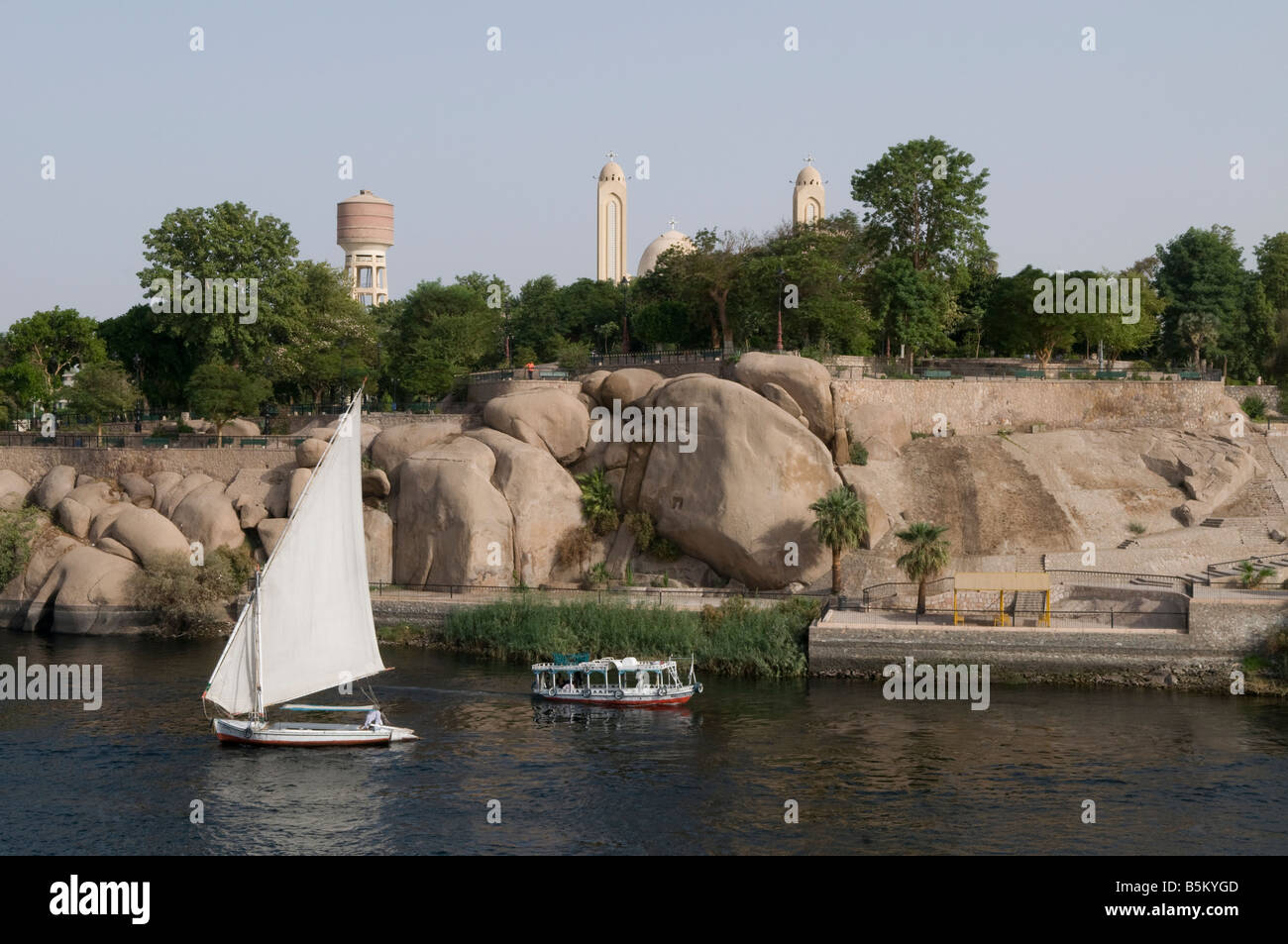 A tour boat and a traditional Felucca boat sailing on the Nile river in ...