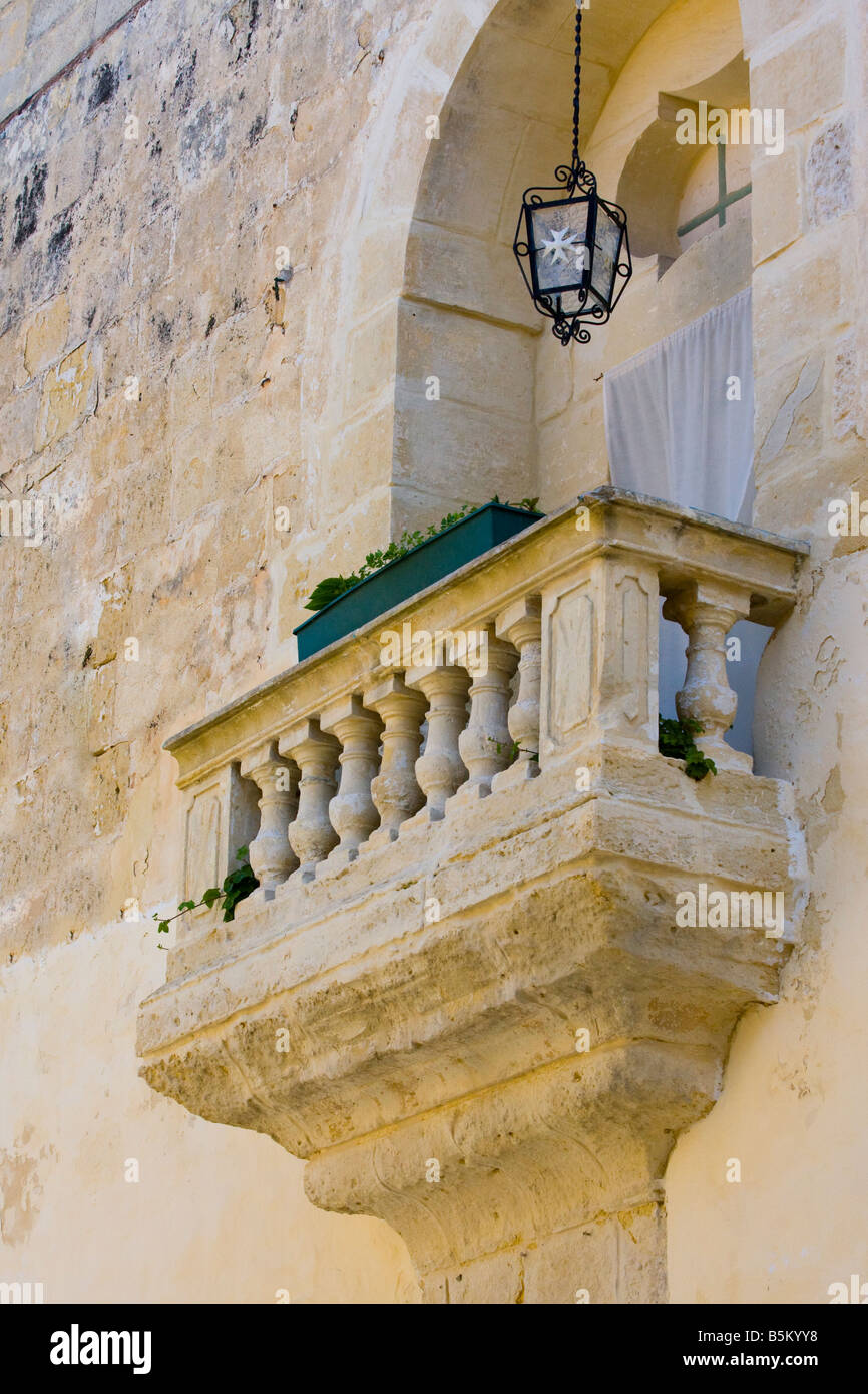 Stone balcony with cast iron lamp containing the eight pointed cross at Mdina Stock Photo