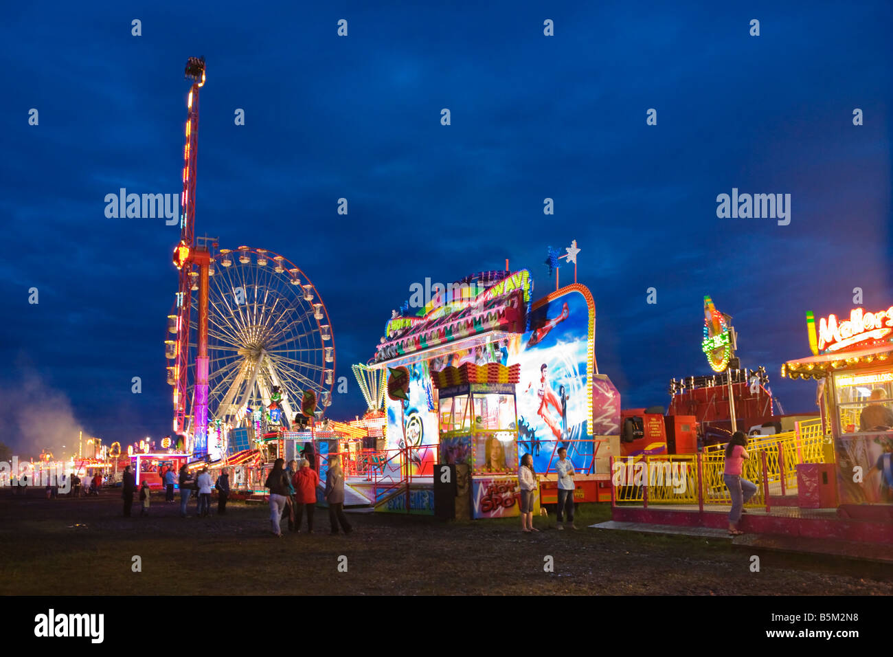 Night time photograph of various rides at a fun fair (specifically 'The Hoppings' annual fair on