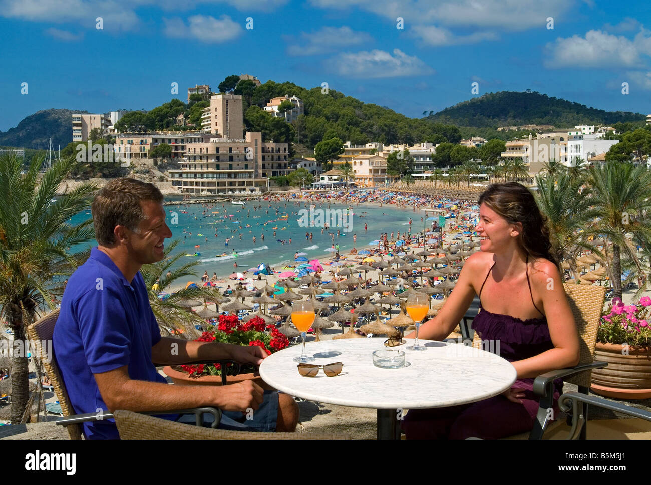 Couple on terrace overlooking Paguera Beach, Mallorca, Balearics, Spain Stock Photo