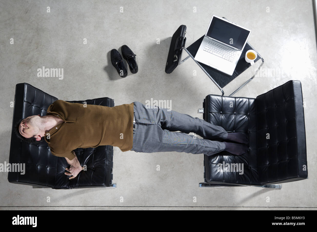 Businessman practicing yoga at office Stock Photo