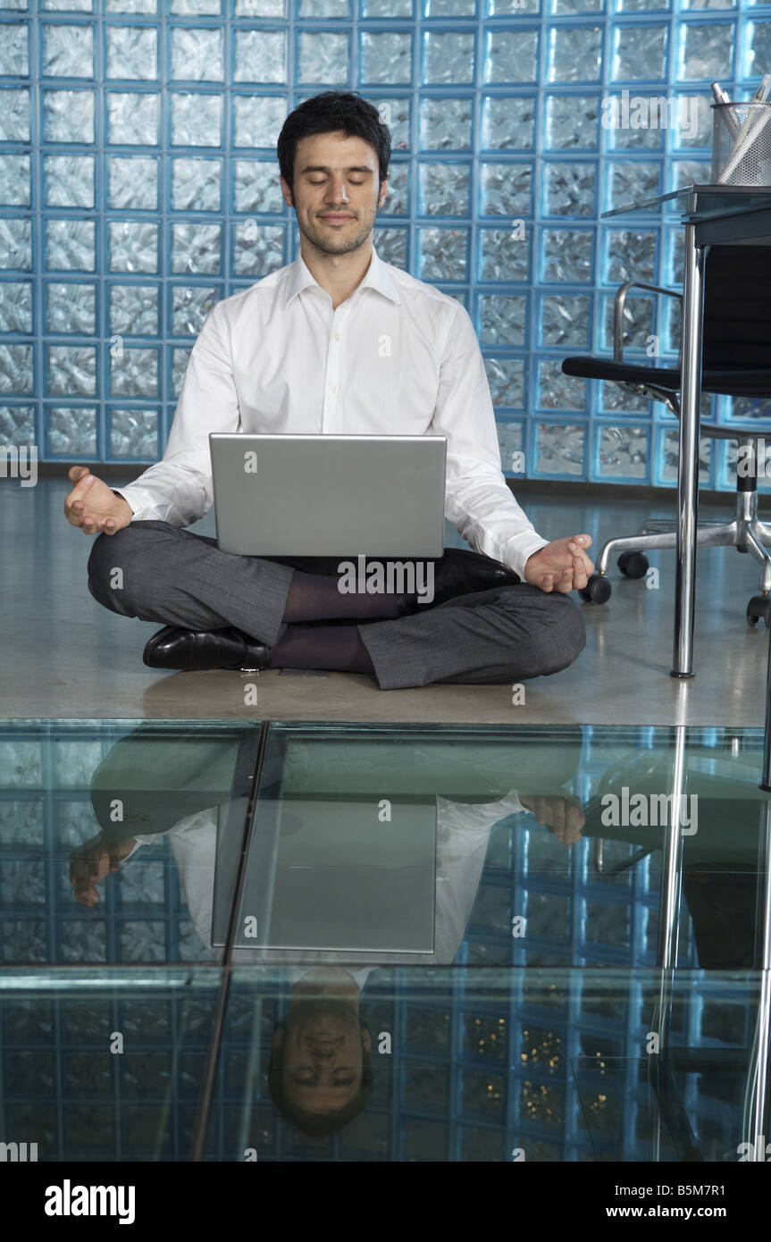 Businessman practicing yoga at the office Stock Photo - Alamy
