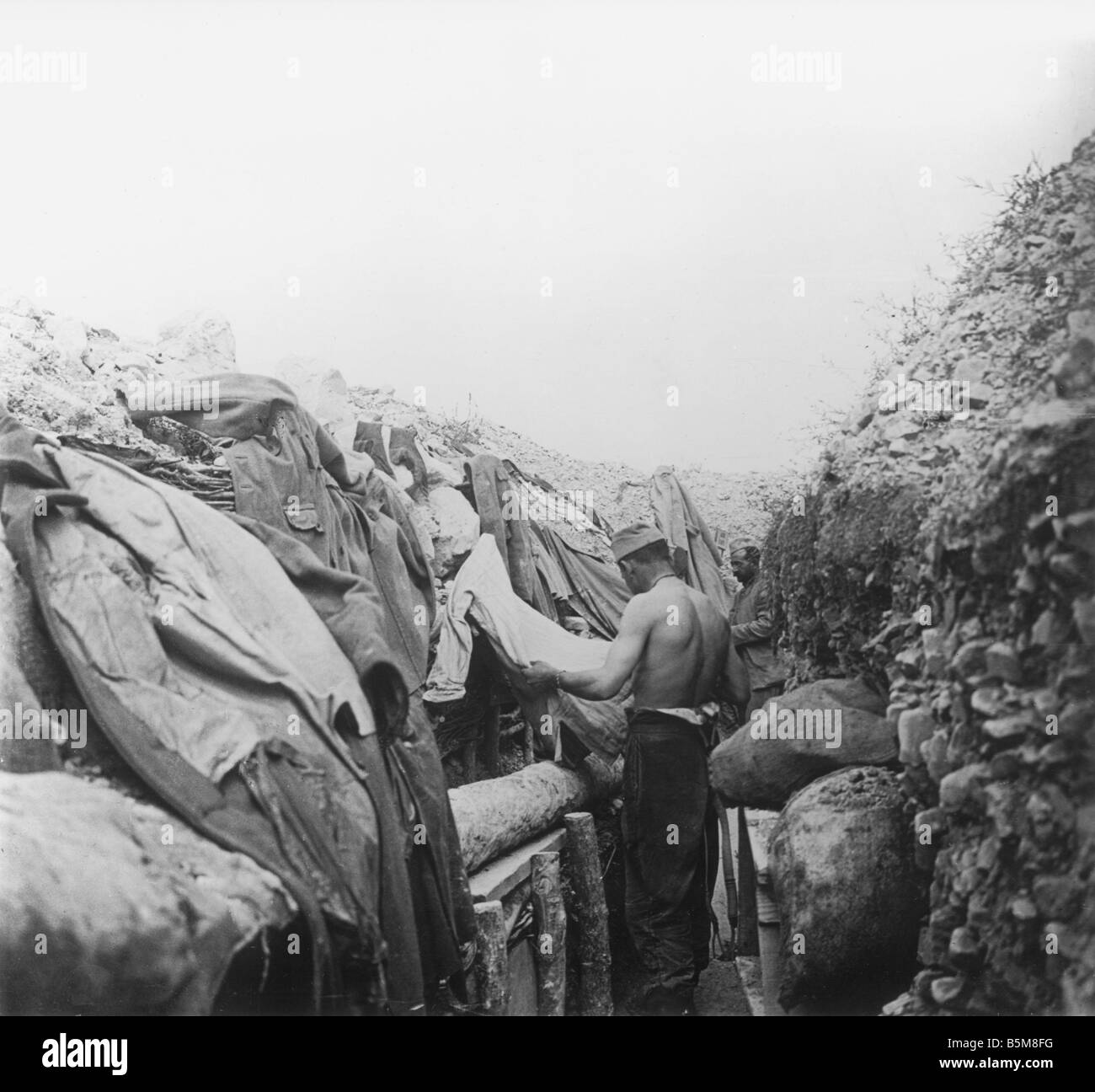 2 G55 F1 1917 19 E Soldier searches for lice WWI History World War One France Trench warfare A French soldier removes lice from Stock Photo