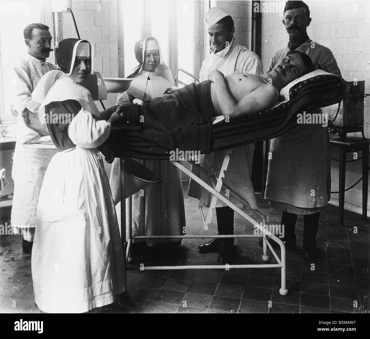 2 M60 L1 1917 15 E WWI French field hospital Photo Military Medical care Medical treatment for a wounded man in a French field h Stock Photo