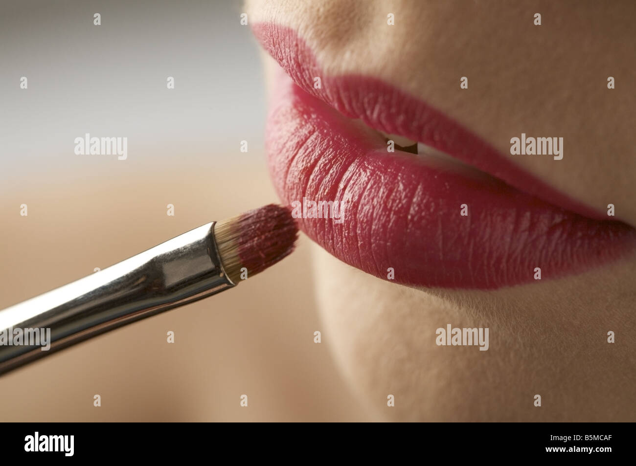 A woman having lipstick applied with a brush Stock Photo Alamy