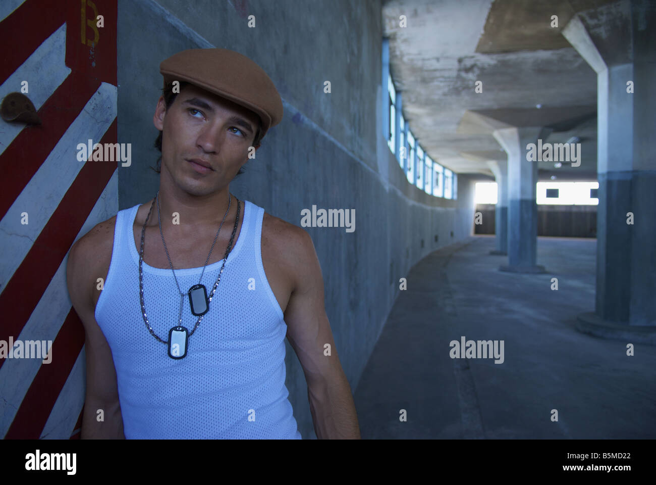 A young man leaning against a wall Stock Photo - Alamy