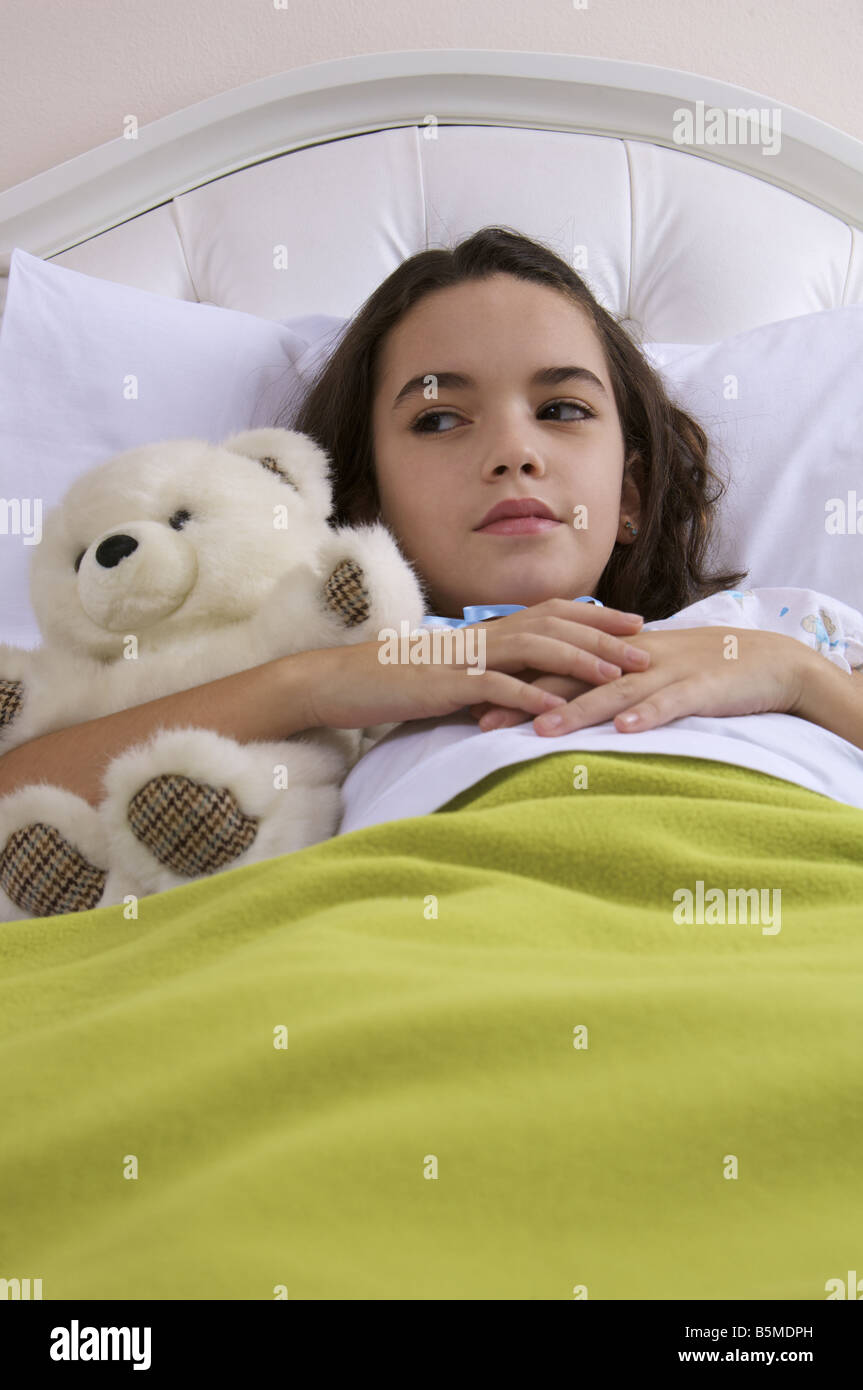 A little girl in bed with a teddy bear Stock Photo - Alamy