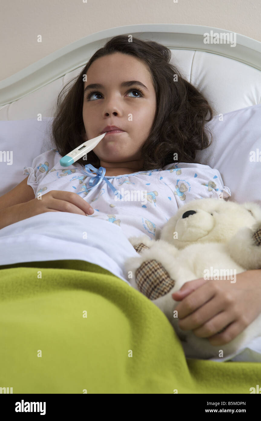 A little girl in bed getting her temperature taken Stock Photo Alamy