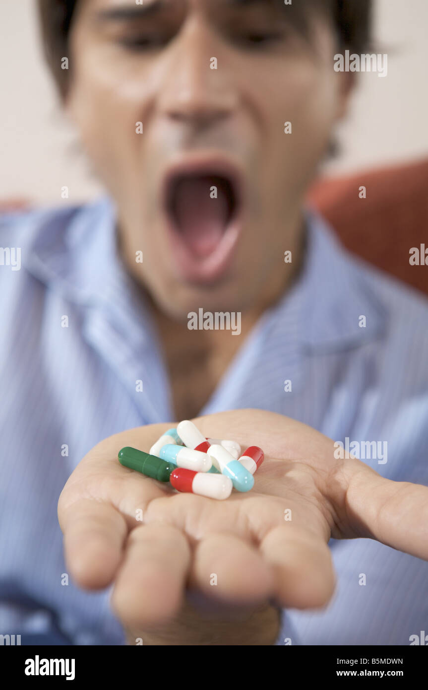 A man with a hand full of pills Stock Photo