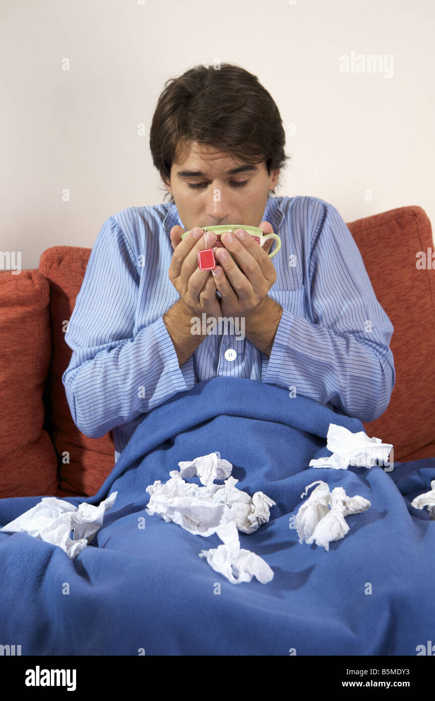 A sick man drinking from a cup Stock Photo Alamy
