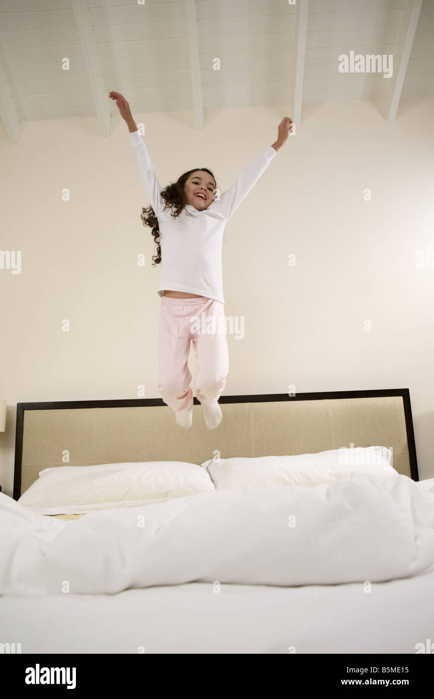 A little girl jumping on a bed Stock Photo Alamy